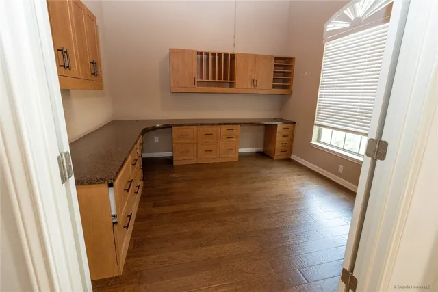 a view of a hallway with wooden floor and stairs