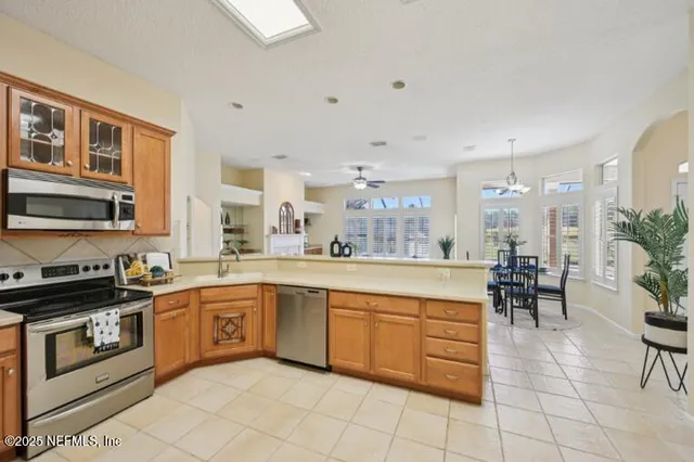 an empty room with windows and chandelier fan