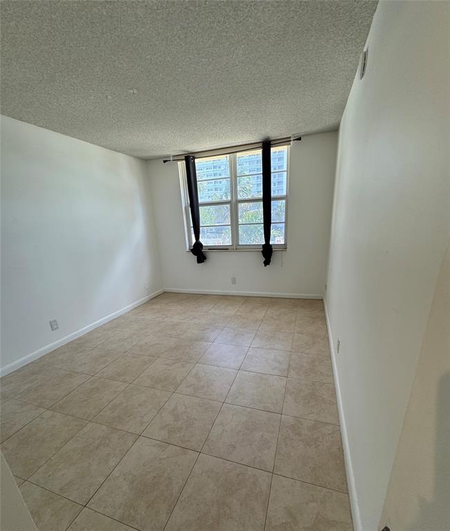 1009 North Ocean Boulevard, Unit 212 Pompano Beach, FL 33062 - Photo 4 of 23 an empty room with windows