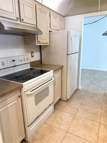 a kitchen with a stove top oven and refrigerator