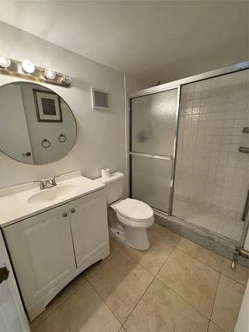 a spacious bathroom with a toilet sink and mirror