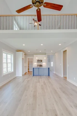 an empty room with windows and fan