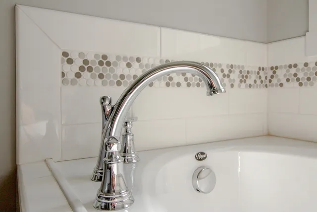 a spacious bathroom with a granite countertop sink and washing machine