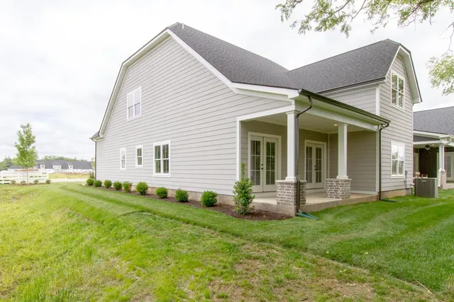 a kitchen with a sink dishwasher a stove a dining table and chairs with wooden floor