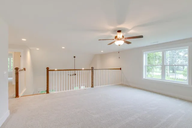 a view of an empty room with wooden floor fireplace and a window