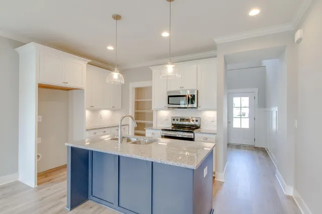 a kitchen with granite countertop a sink stainless steel appliances and cabinets