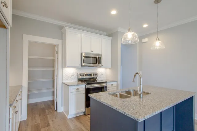 a kitchen with a sink a microwave a stove and refrigerator