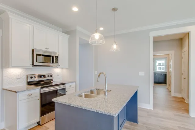 a kitchen with kitchen island wooden floors and stainless steel appliances