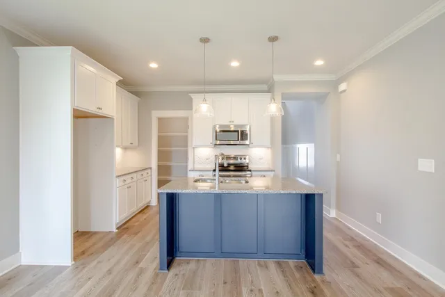 a view of kitchen with kitchen island granite countertop a stove top oven a sink and a refrigerator
