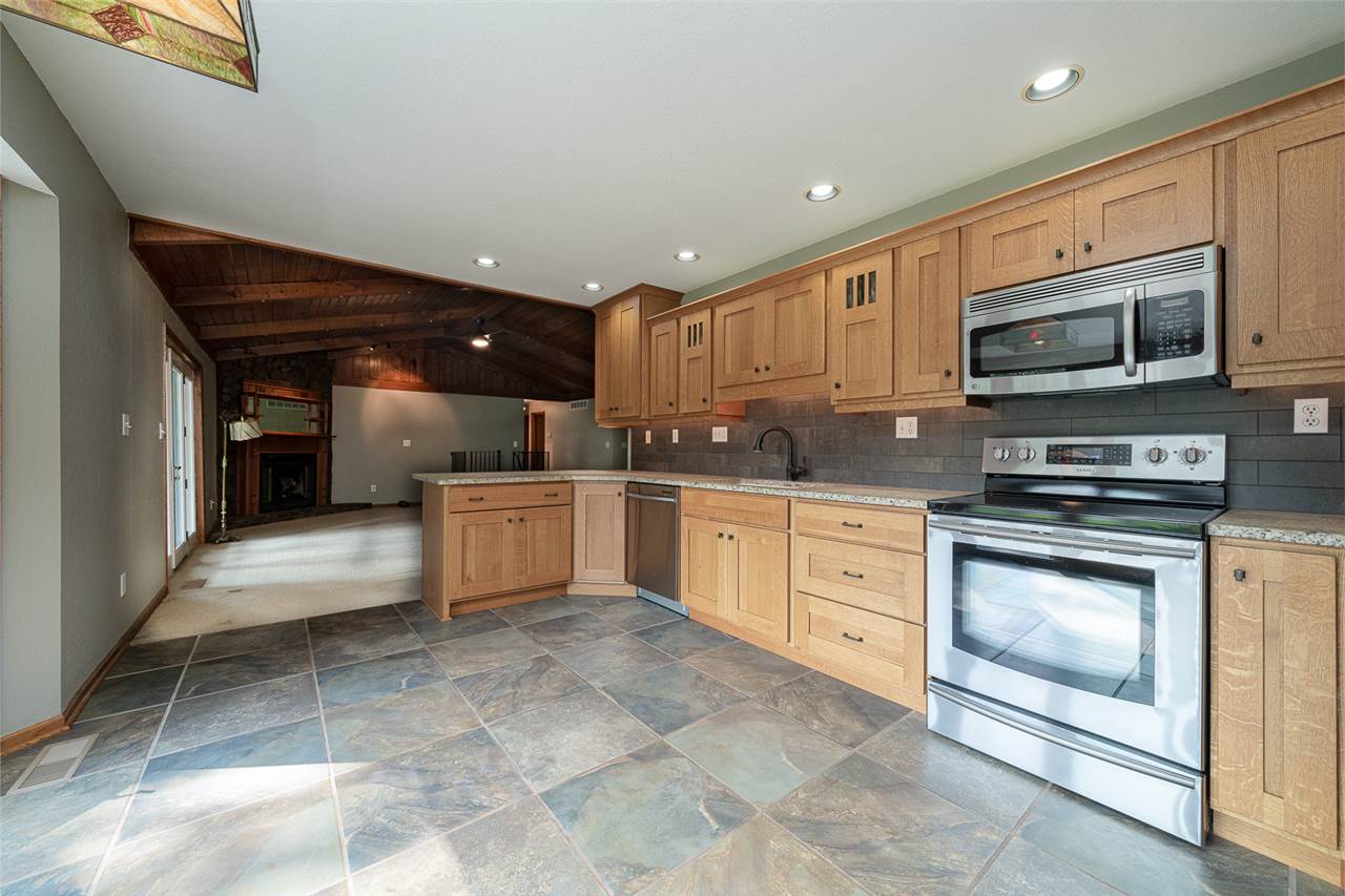 9443 Oak Ridge Drive Rochelle, IL 61068 - Photo 8 of 40 a kitchen with stainless steel appliances granite countertop a stove a sink and a microwave