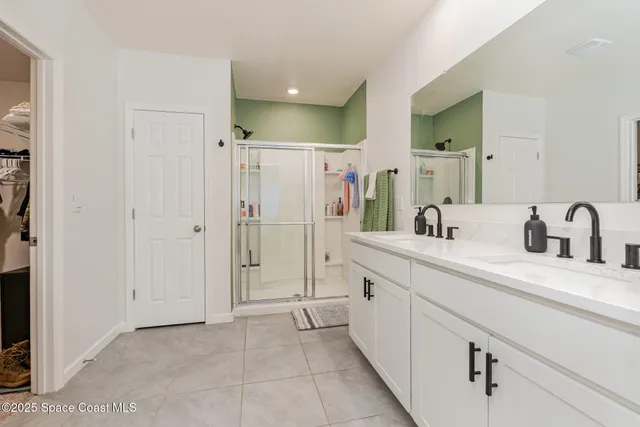 a spacious bathroom with a shower sink and mirror