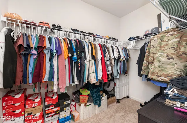 a view of walk in closet with clothes and shoes