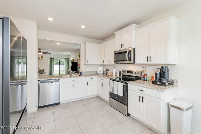a kitchen with white cabinets sink and stainless steel appliances
