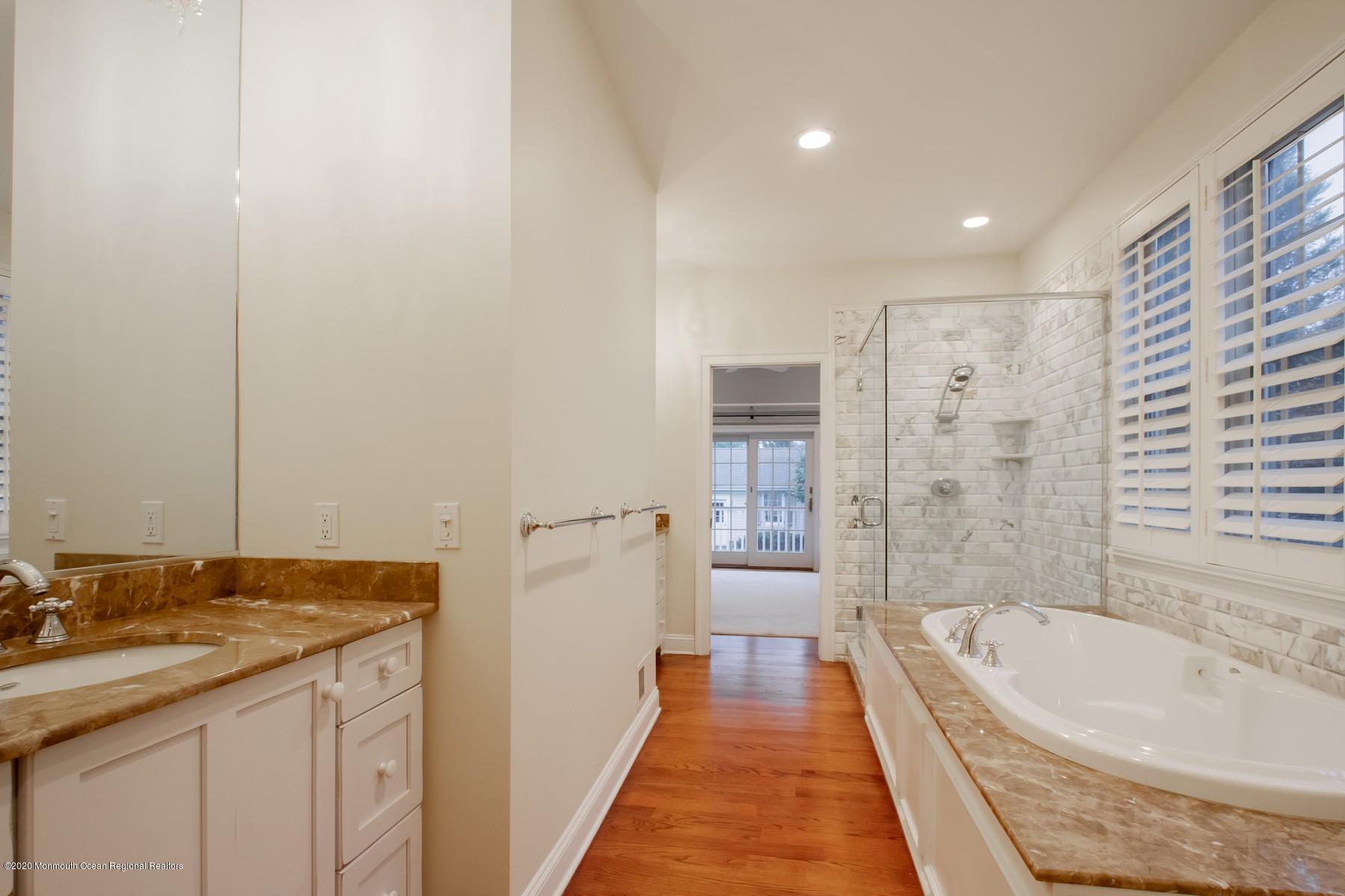 63 River Road Rumson, NJ 07760 - Photo 22 of 37 a bathroom with a granite countertop sink a bathtub and a shower