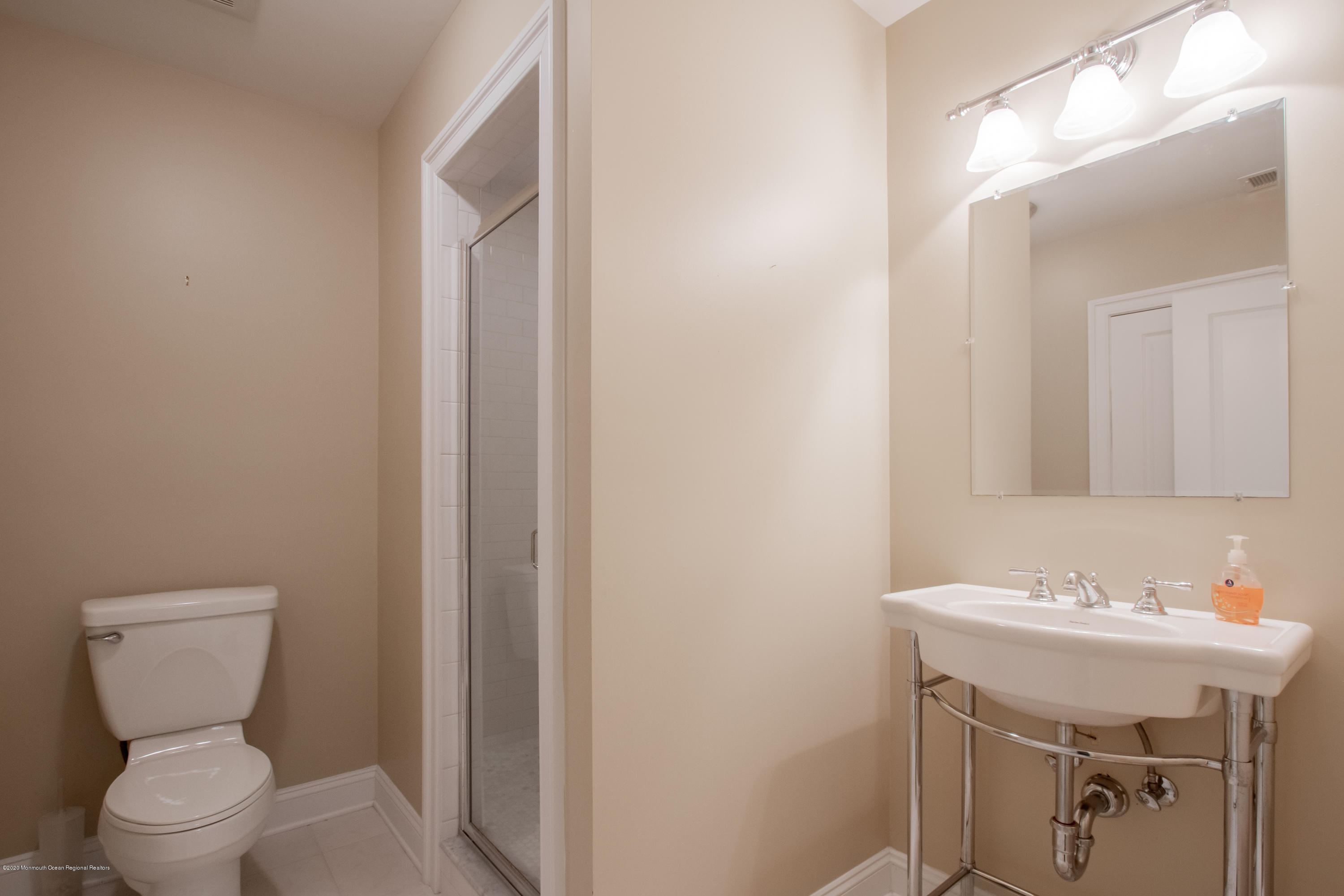 63 River Road Rumson, NJ 07760 - Photo 33 of 37 a bathroom with a toilet sink and mirror