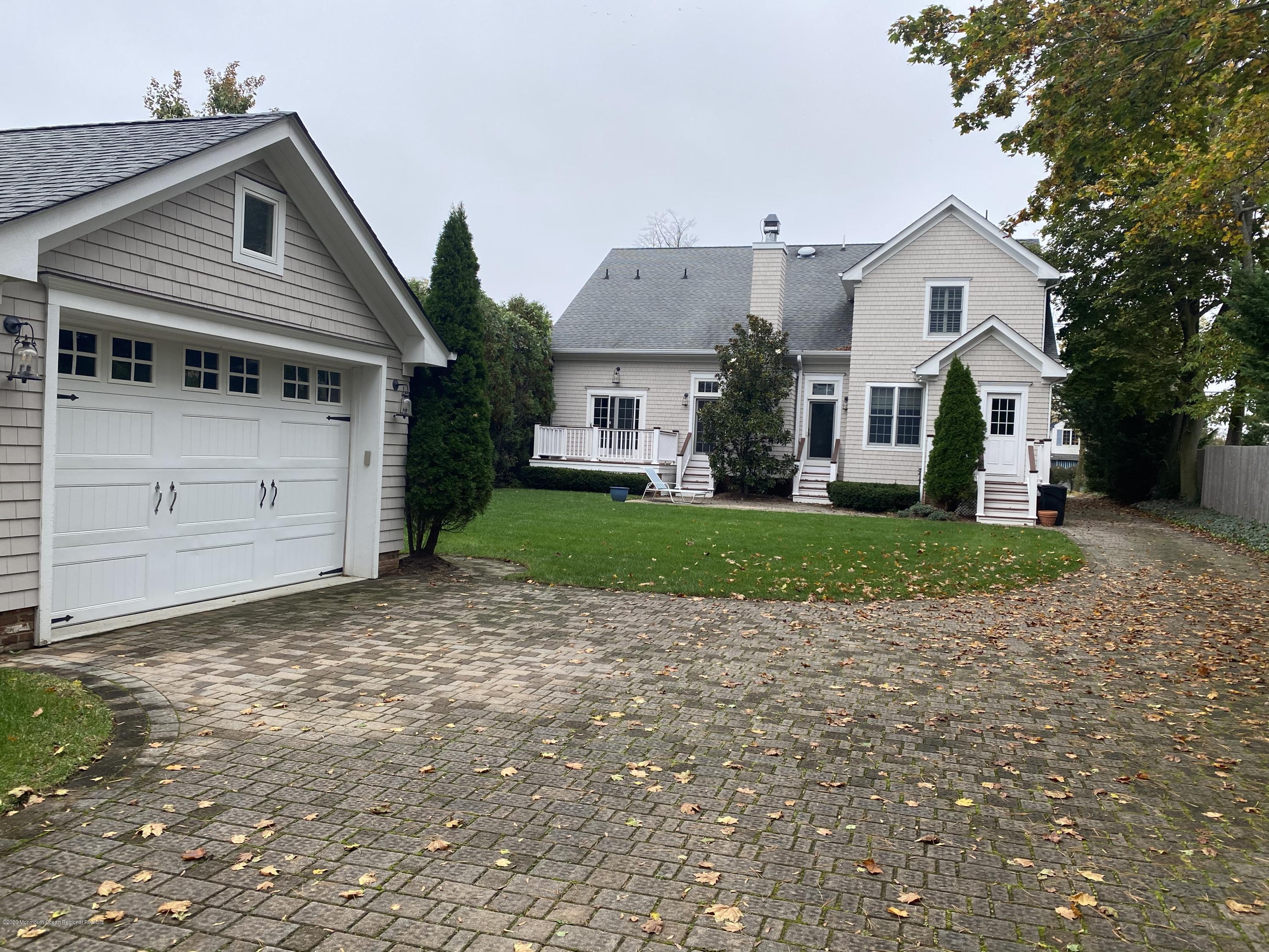 63 River Road Rumson, NJ 07760 - Photo 35 of 37 a view of a white house with a big yard and large trees