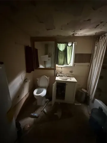 a bathroom with a toilet sink and mirror