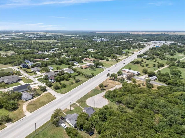 an aerial view of residential houses with outdoor space and trees