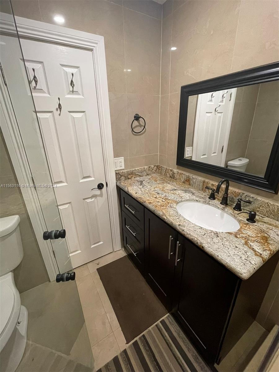 11810 Southwest 176th Street Miami, FL 33177 - Photo 12 of 15 a bathroom with a granite countertop sink toilet and shower