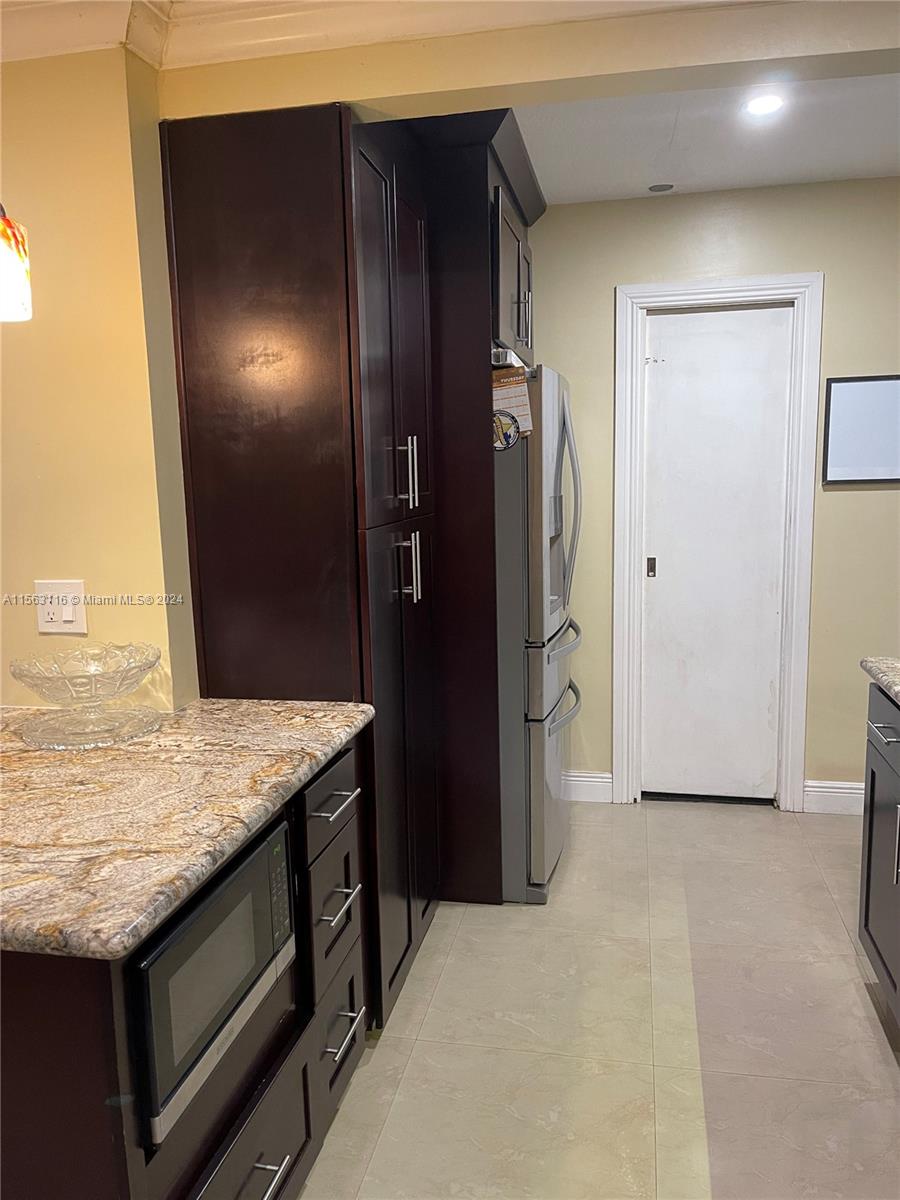 11810 Southwest 176th Street Miami, FL 33177 - Photo 3 of 15 a view of kitchen island cabinets and refrigerator