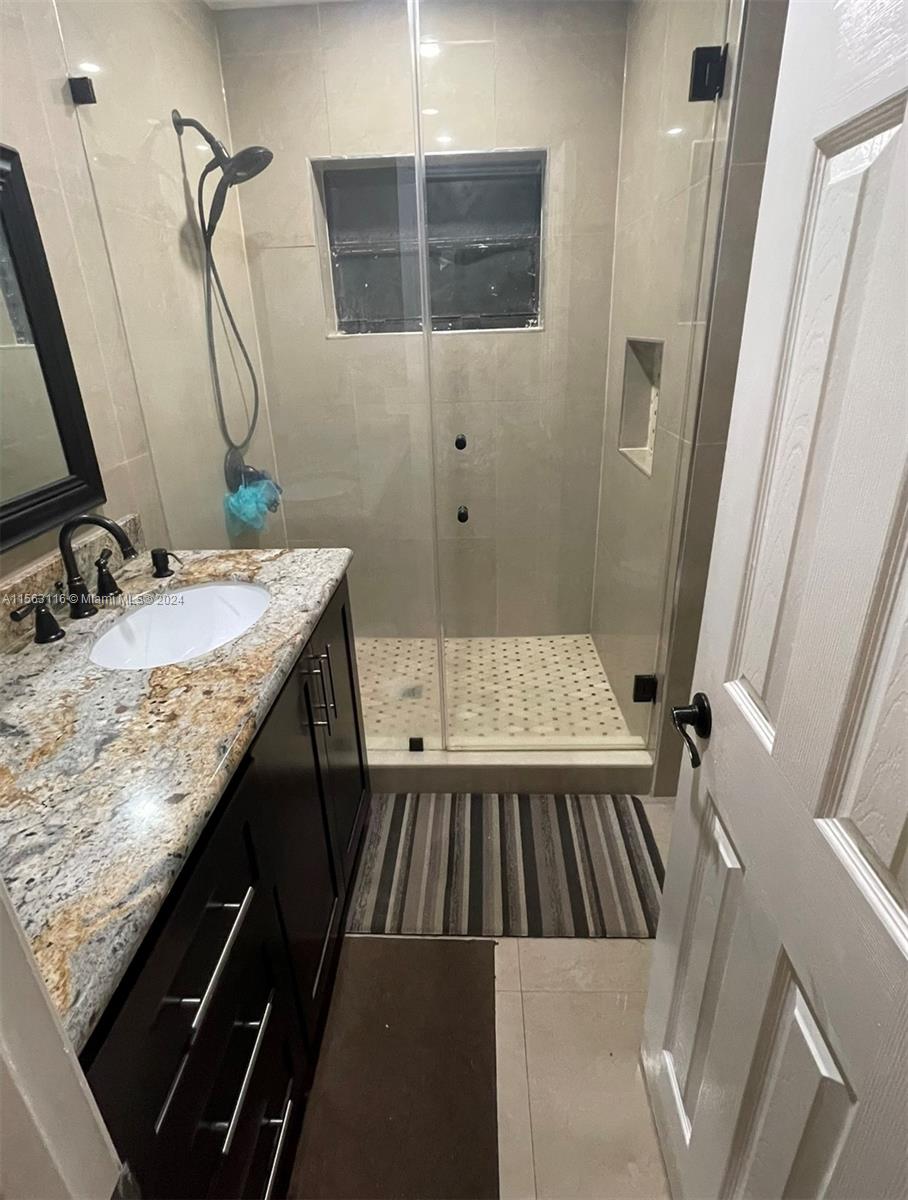 11810 Southwest 176th Street Miami, FL 33177 - Photo 8 of 15 a bathroom with a granite countertop sink a mirror and shower