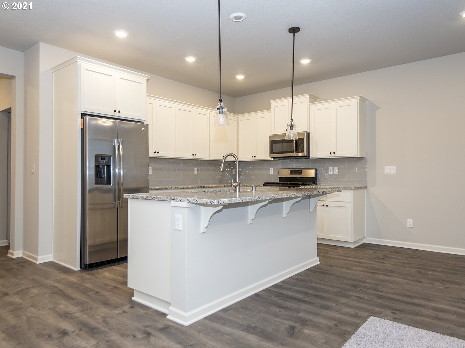 3712 South 42nd Place Ridgefield, WA 98642 - Photo 19 of 29 a kitchen with kitchen island a counter top space appliances and a ceiling fan