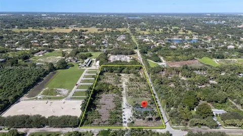 an aerial view of residential houses with outdoor space and trees