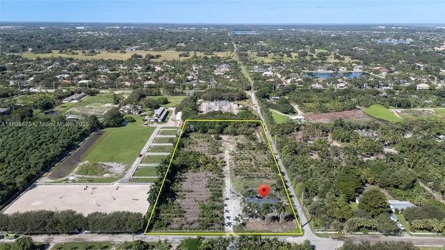 an aerial view of residential houses with outdoor space and trees