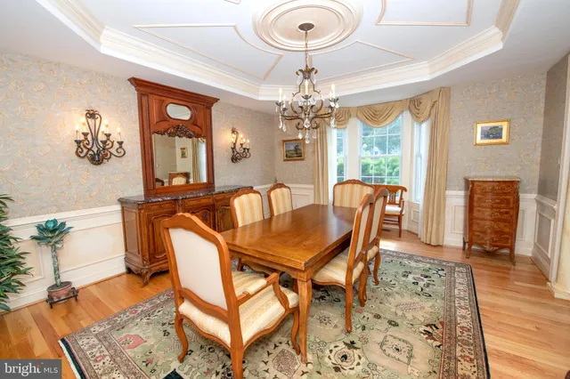 a view of a dining room with furniture a chandelier and wooden floor