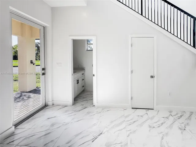 a view of a hallway with wooden floor and furniture