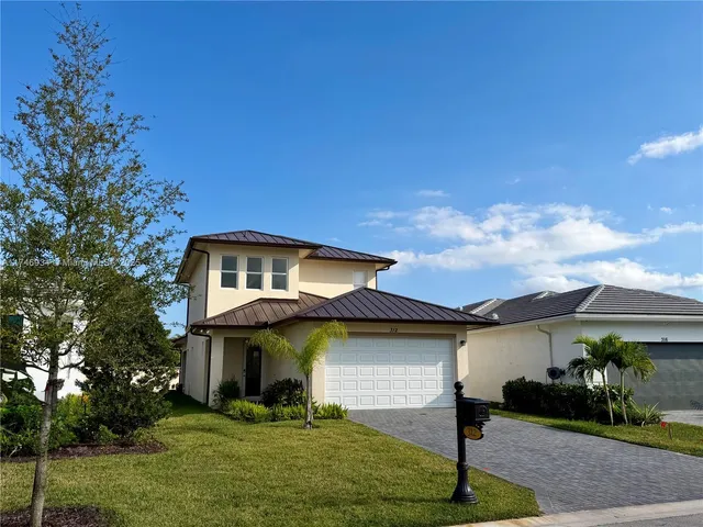 a front view of a house with a yard and garage