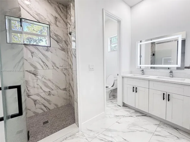 a view of a white building with a garden