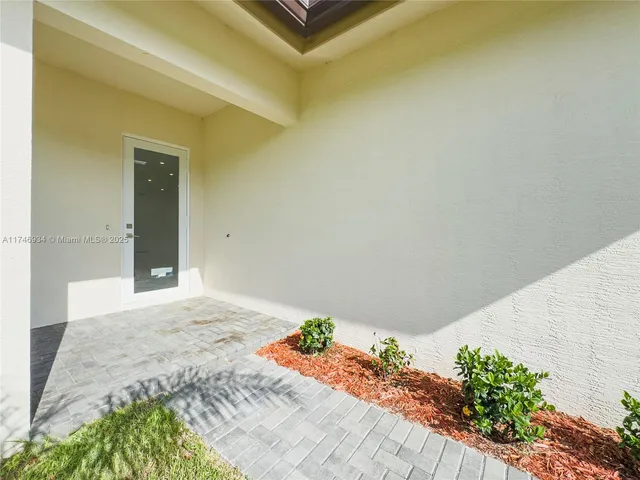 a view of an empty room with stairs and a window