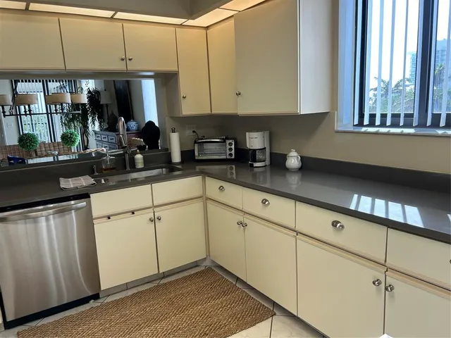 a kitchen with granite countertop white cabinets and white appliances