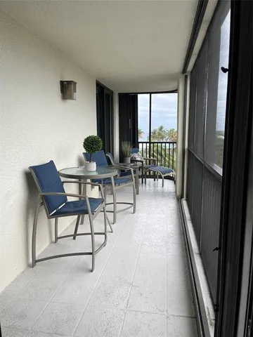 a dining room with furniture and a floor to ceiling window