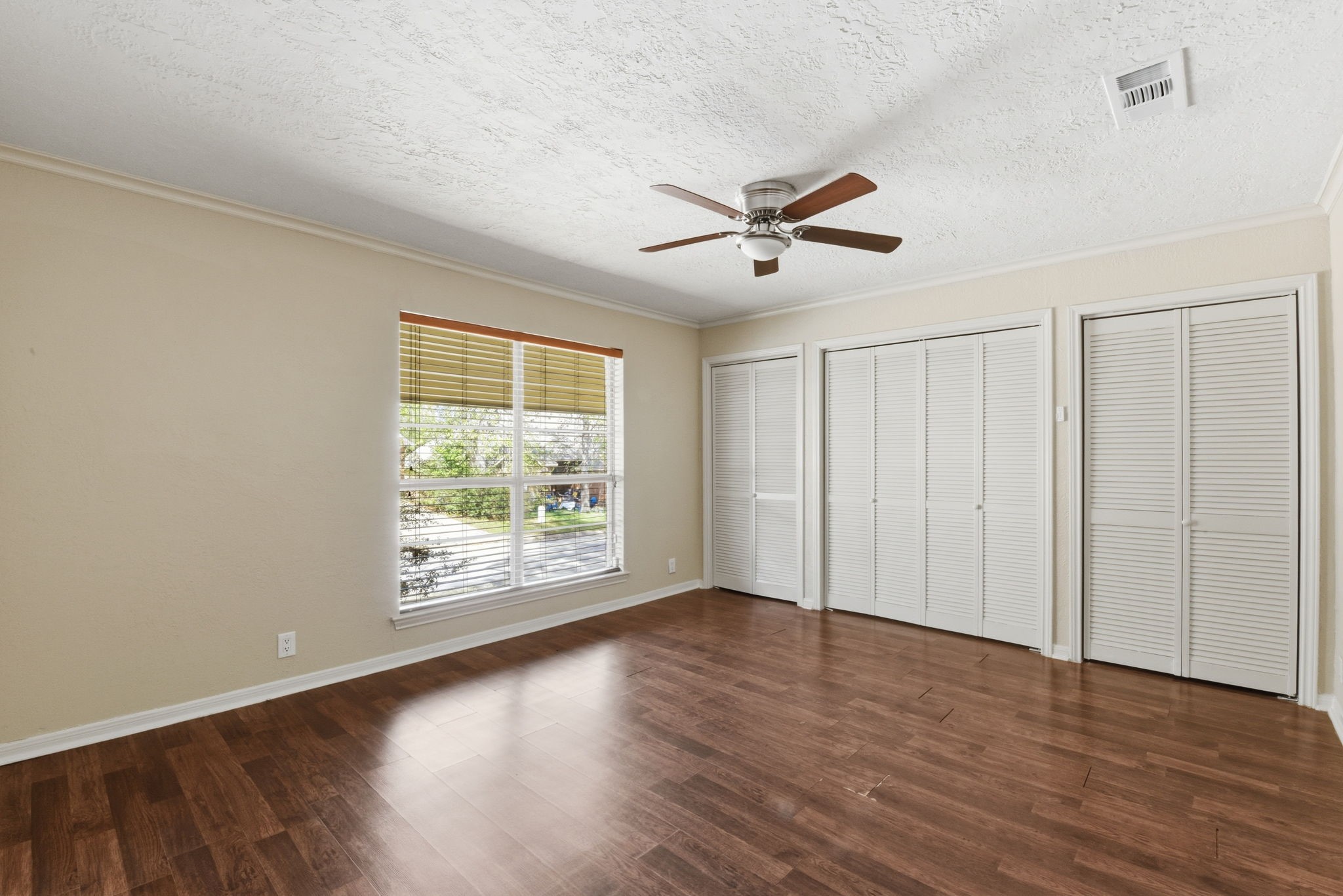 9052 Zapata Way Willis, TX 77378 - Photo 13 of 45 an empty room with wooden floor chandelier fan and windows