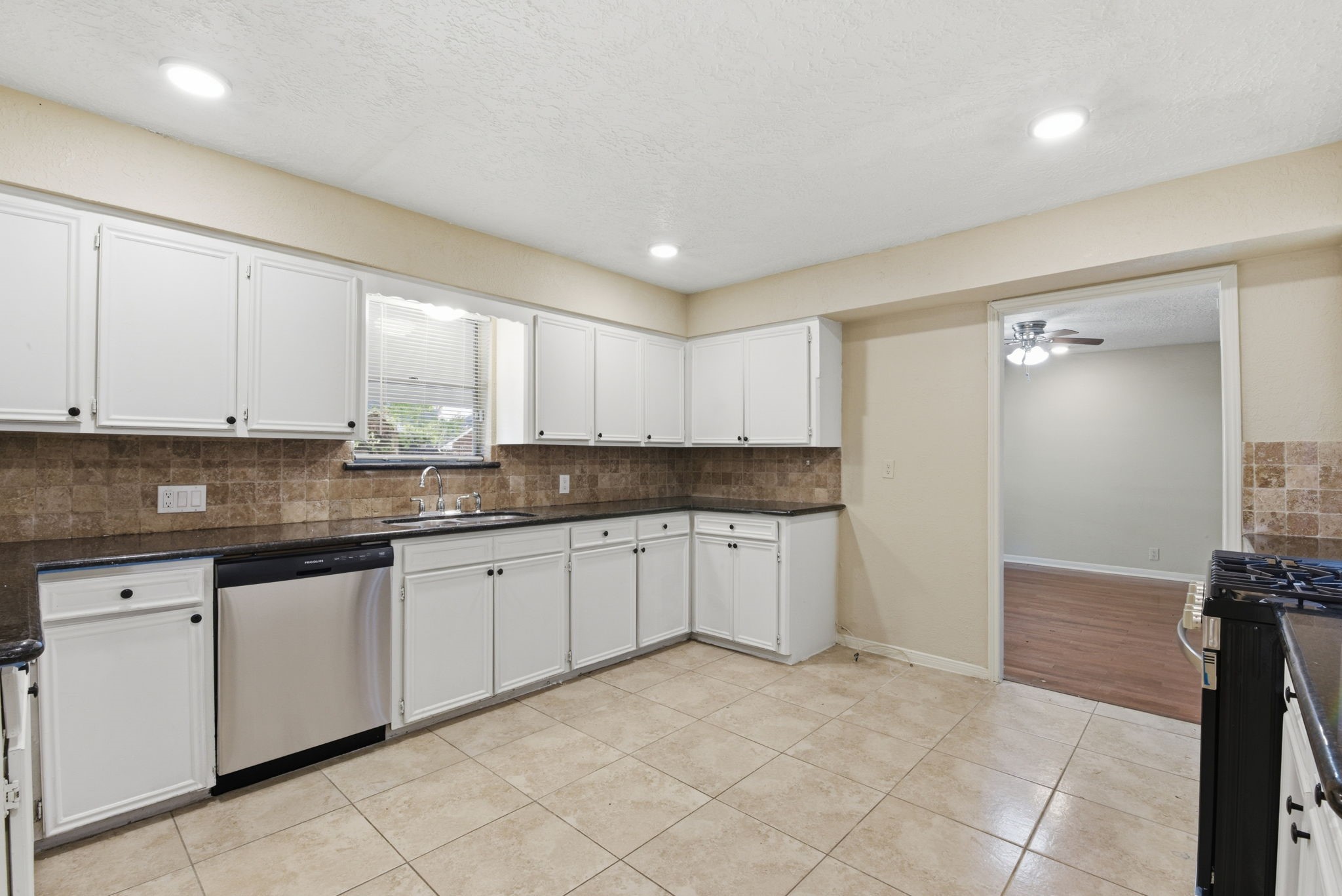 9052 Zapata Way Willis, TX 77378 - Photo 19 of 45 a kitchen with granite countertop a sink and white cabinets