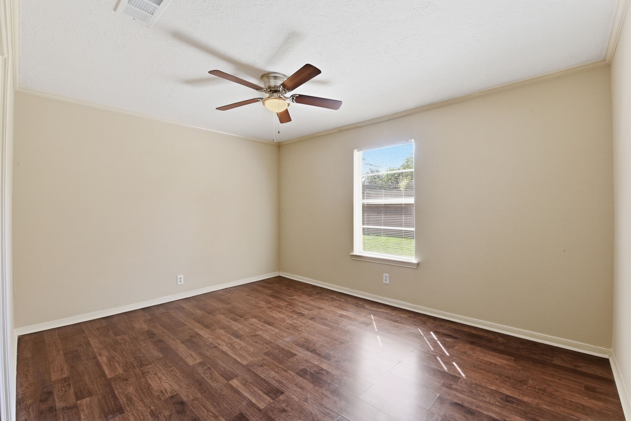9052 Zapata Way Willis, TX 77378 - Photo 30 of 45 an empty room with wooden floor fan and windows
