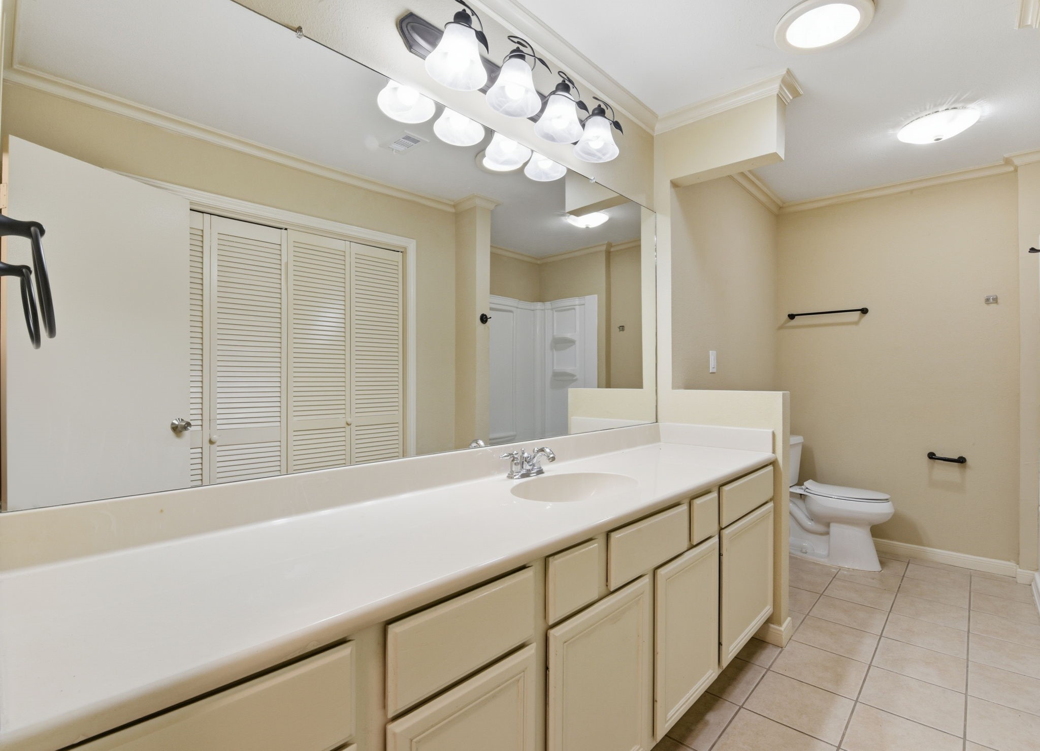 9052 Zapata Way Willis, TX 77378 - Photo 32 of 45 a bathroom with a sink a toilet and a large mirror