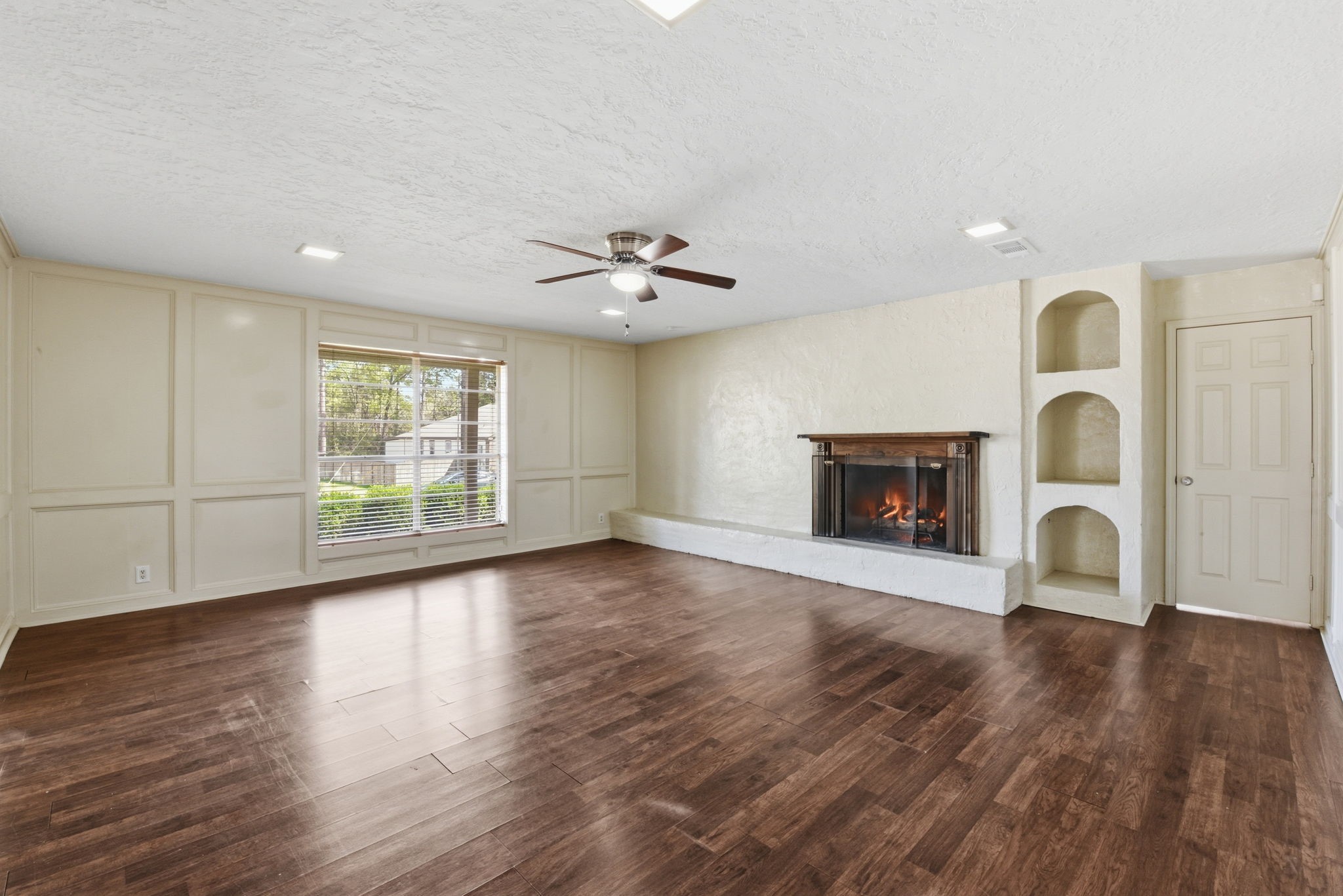 9052 Zapata Way Willis, TX 77378 - Photo 10 of 45 an empty room with wooden floor a fireplace and windows