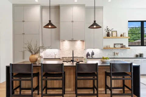 a kitchen with stainless steel appliances granite countertop a stove a sink a microwave a dining table and chairs