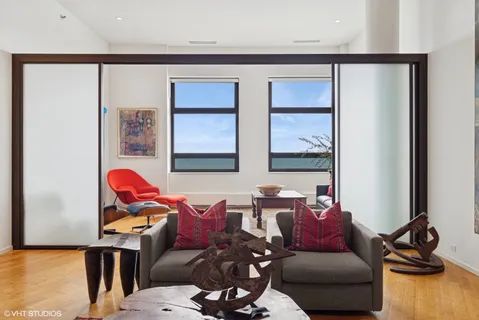 a view of a hallway with a large mirror and a wooden bench