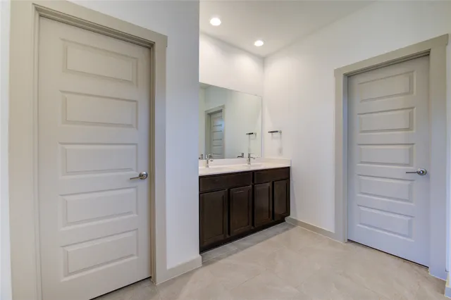 a bathroom with a double vanity sink a shower and a mirror