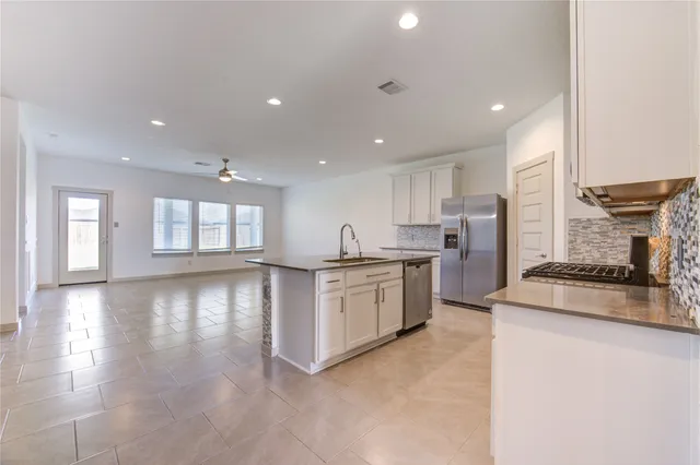 a open kitchen with white cabinets sink and stainless steel appliances