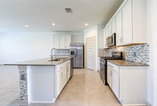 a kitchen with microwave cabinets and stove top oven