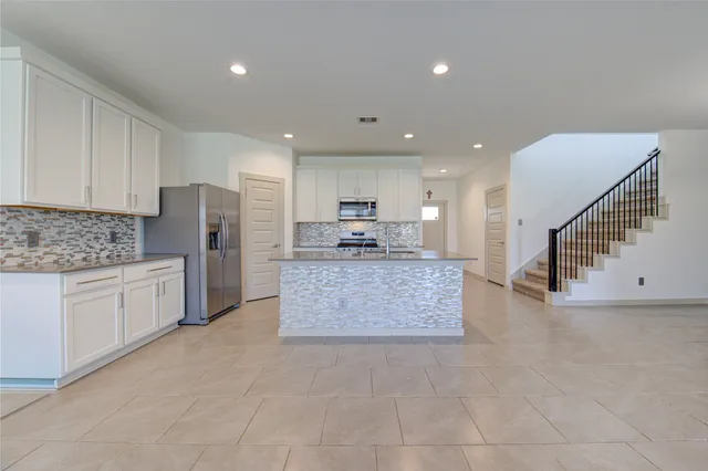 a kitchen with stainless steel appliances a refrigerator sink stove microwave and cabinets