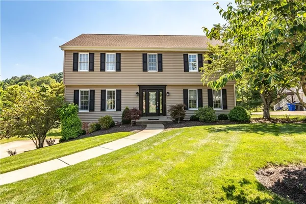 a front view of house with yard and green space