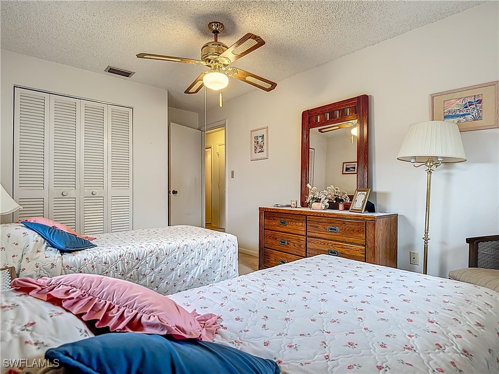 19040 Geranium Road Fort Myers, FL 33967 - Photo 29 of 42 a bedroom with two beds and a chandelier