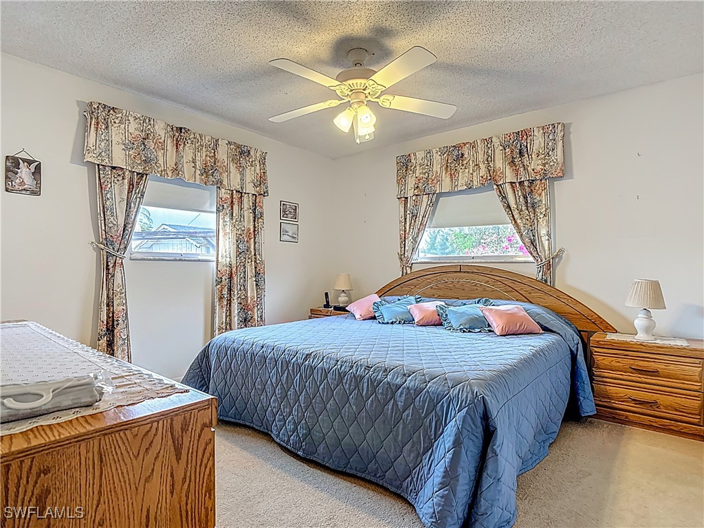 19040 Geranium Road Fort Myers, FL 33967 - Photo 32 of 42 a bedroom with a bed and a chandelier