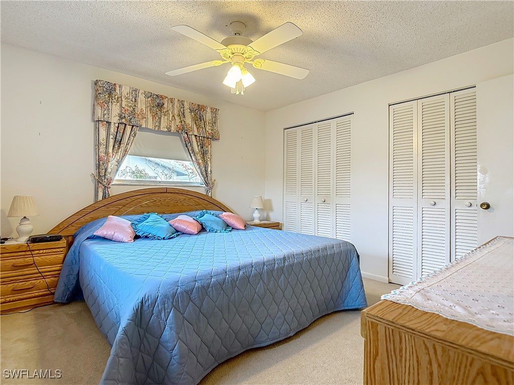 19040 Geranium Road Fort Myers, FL 33967 - Photo 33 of 42 a bedroom with a bed and a chandelier